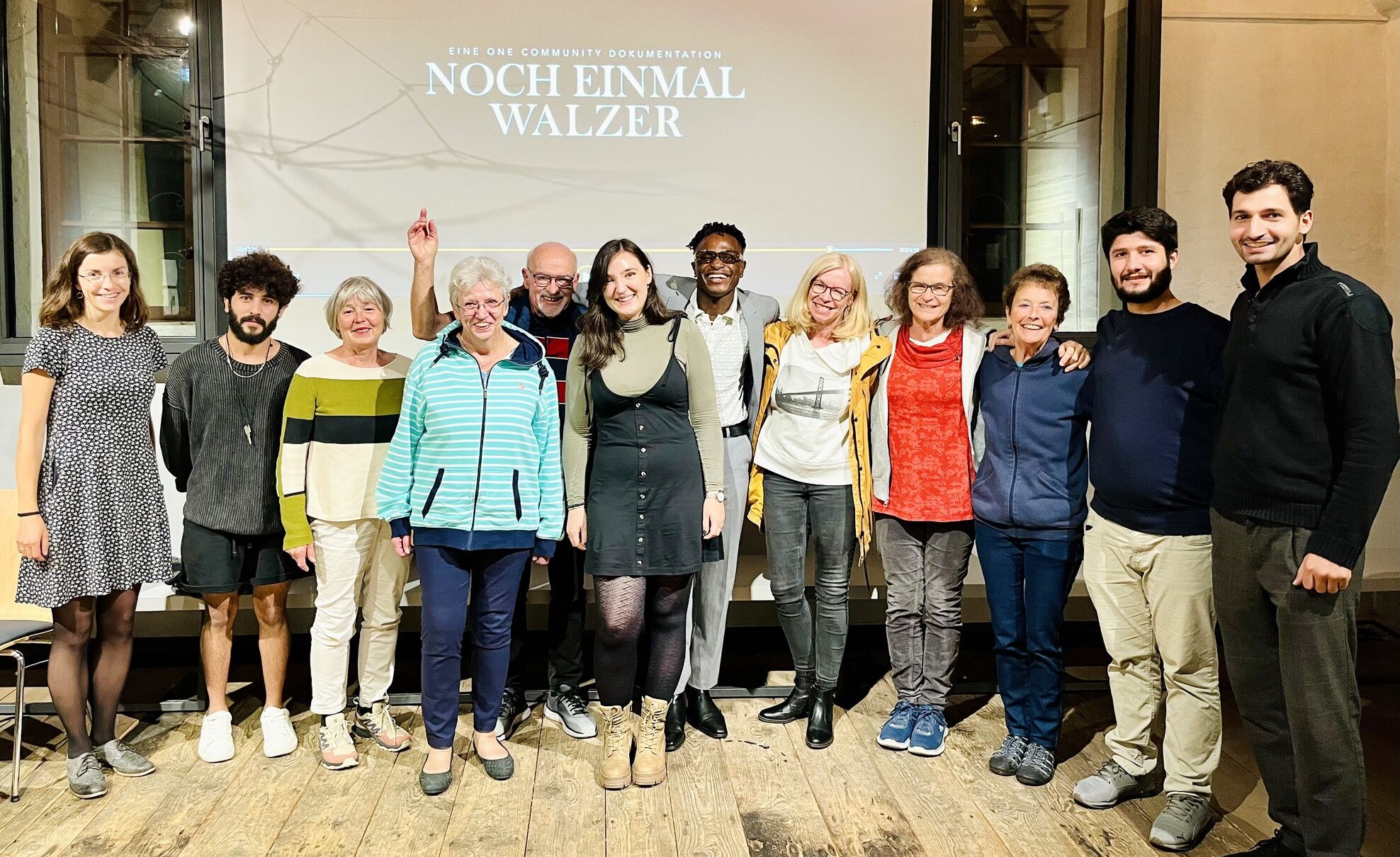 Adetayo with the Museum Friedland team and audience members in front of the screen after the screening of Noch einmal Walzer